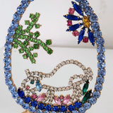 Decorative peacock brooch with colorful gemstones on a white background